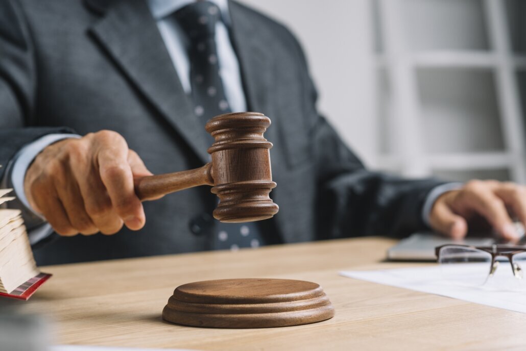 male_judge_lawyer_giving_verdict_by_hitting_mallet_gavel_sounding_block